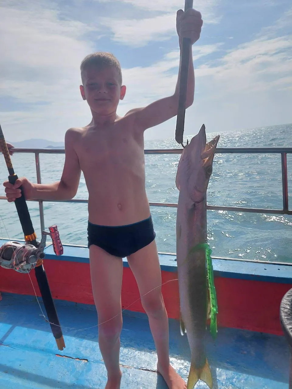 Enfant fier de sa prise lors d'une peche en famille a Koh Samui